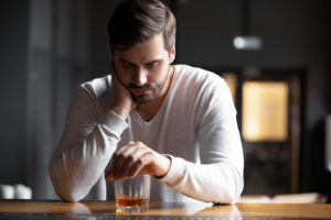 A man thinking with a brandy in his hands
